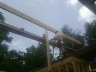 Carpenter setting a ridge beam over a new addition frame — Ice Dam Removal by Roofing Brothers in Missoula