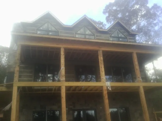 Dormers and porch framing on a large log home under construction — Roof Coating work by our crew in Missoula